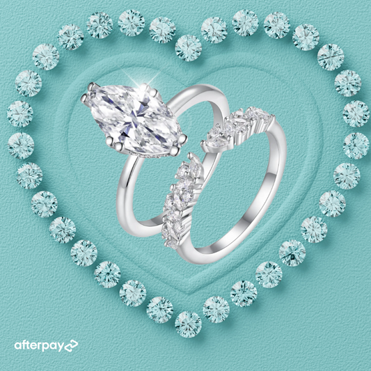 Silver marquise ring with a large diamond and smaller diamonds on a turquoise background with heart design.