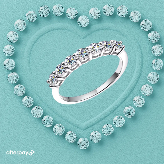 Silver wedding ring with moissanite diamonds on a turquoise background with heart design