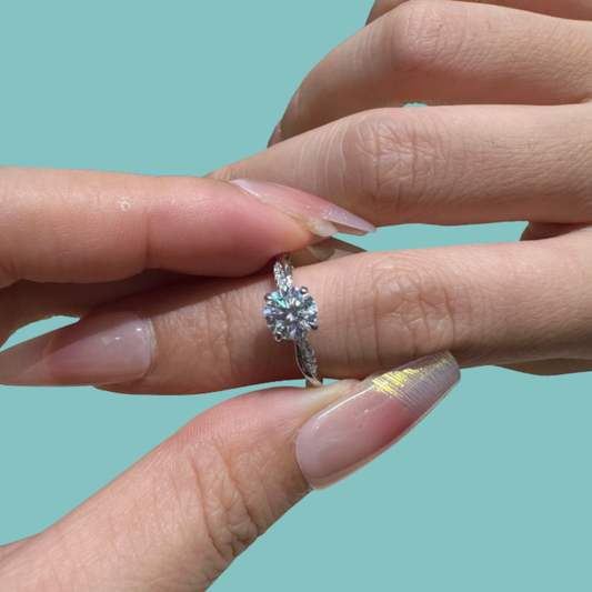 Twist band moissanite ring with round centre stone and accent stones