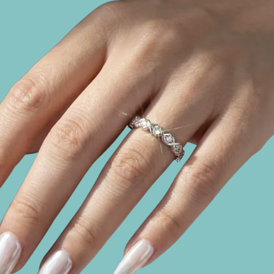 Silver moissanite eternity style ring with alternating round stones and kiss inspired X accents