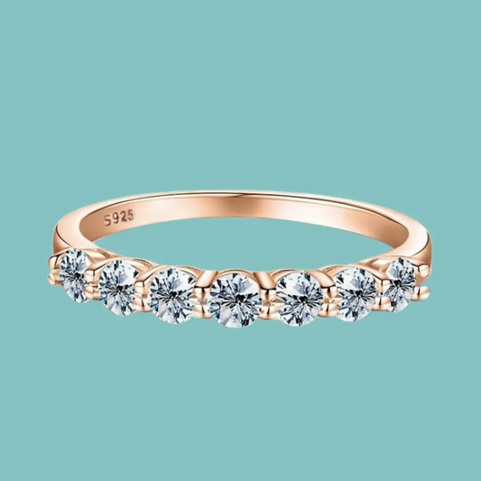 Rose gold ring with diamonds on a teal background