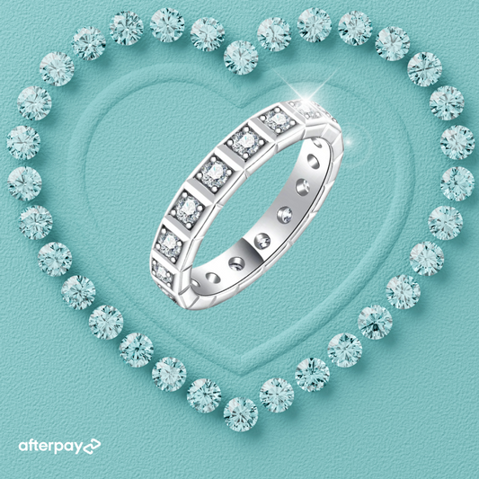 A Princess Cut Moissanite Eternity Ring surrounded by small blue crystals, displayed on a heart-shaped background.