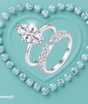 Silver marquise ring with a large diamond and smaller diamonds on a turquoise background with heart design.