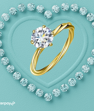 Gold ring with a large diamond surrounded by smaller diamonds on a light blue background, featuring Afterpay logo.