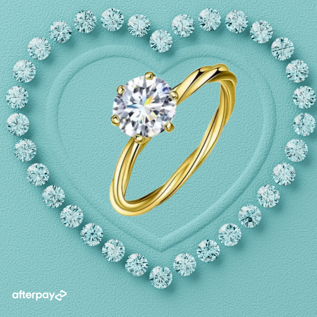 Gold ring with a large diamond surrounded by smaller diamonds on a light blue background, featuring Afterpay logo.