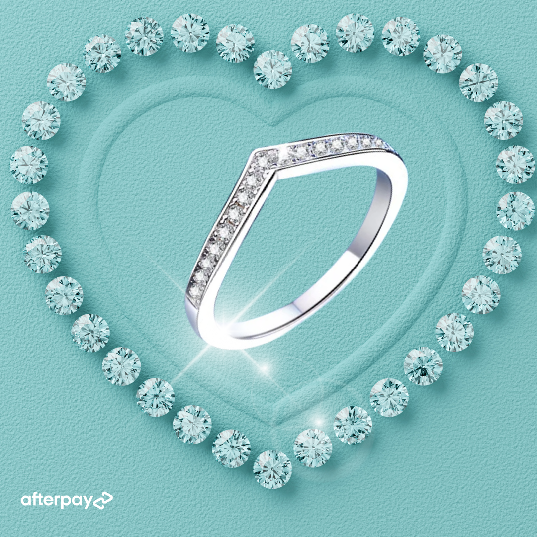 V-shaped moissanite wedding band with pavé stones in sterling silver