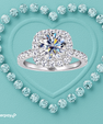 A double-halo diamond engagement ring with a silver-colored band, centered on a textured light blue background with a heart outline made of smaller diamonds. An Afterpay logo is visible in the bottom-left corner.
