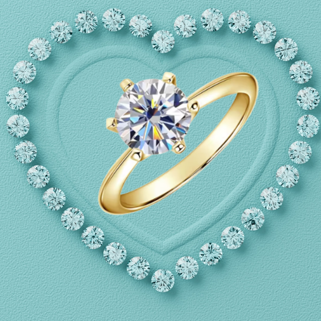 A gold solitaire ring with a round brilliant-cut diamond is centered on a textured light blue background, surrounded by a heart-shaped border of smaller diamonds.