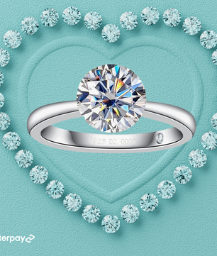 A 2-carat round brilliant moissanite diamond invisible setting ring with an invisible setting, displayed in a heart-shaped setting with surrounding smaller stones.