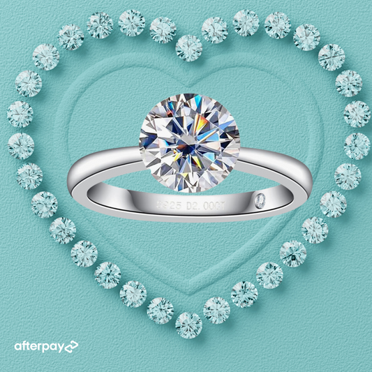 A 2-carat round brilliant moissanite diamond invisible setting ring with an invisible setting, displayed in a heart-shaped setting with surrounding smaller stones.