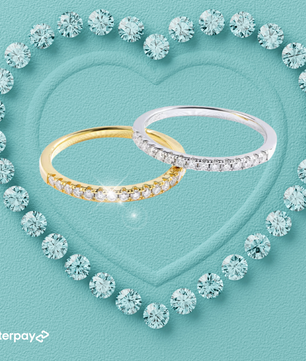 Two Moissanite pavé wedding bands, one with a yellow gold band and the other with a white gold band, surrounded by a heart shape made of moissanites, with the Afterpay logo.