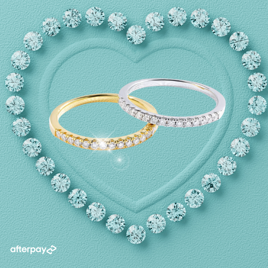 Two Moissanite pavé wedding bands, one with a yellow gold band and the other with a white gold band, surrounded by a heart shape made of moissanites, with the Afterpay logo.
