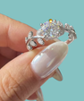 Romantic round moissanite engagement ring with intricate leaf inspired shoulders