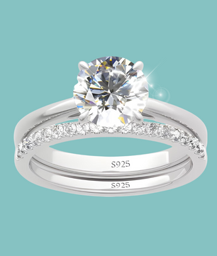 Silver ring with a large diamond and smaller diamonds on a light blue background