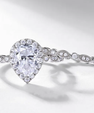 Pear cut moissanite engagement ring set with halo setting and matching band in sterling silver