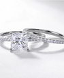 Close-up of a princess cut moissanite ring set with a sparkling solitaire centre and coordinating diamond-style band.