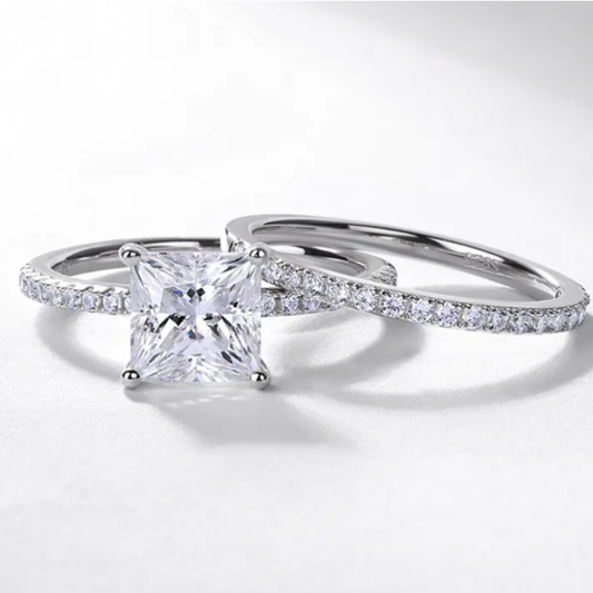 Close-up of a princess cut moissanite ring set with a sparkling solitaire centre and coordinating diamond-style band.