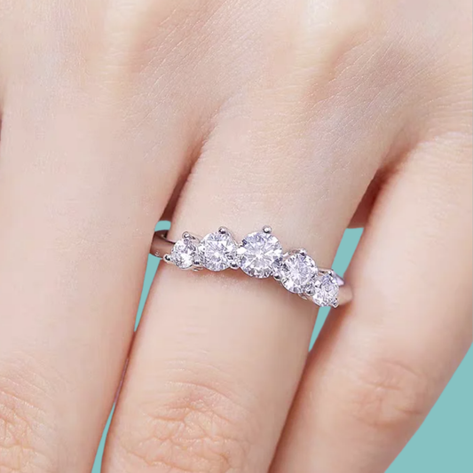 Modern contour ring with claw-set moissanite stones in a curved arc