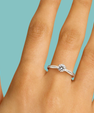 Round cut moissanite engagement style ring with pavé shoulder stones