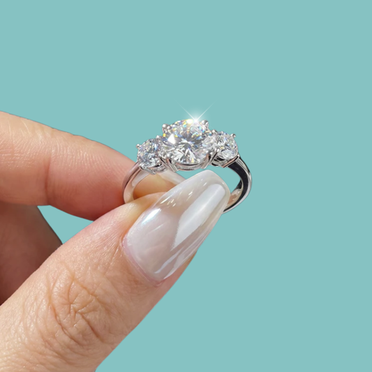 Elegant three stone ring with round centre stone and sparkling side stones