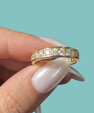Gold eternity-style ring featuring brilliant round stones set around the band
