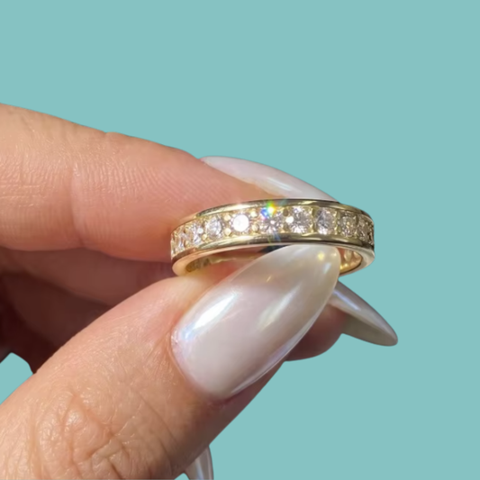 Gold eternity-style ring featuring brilliant round stones set around the band