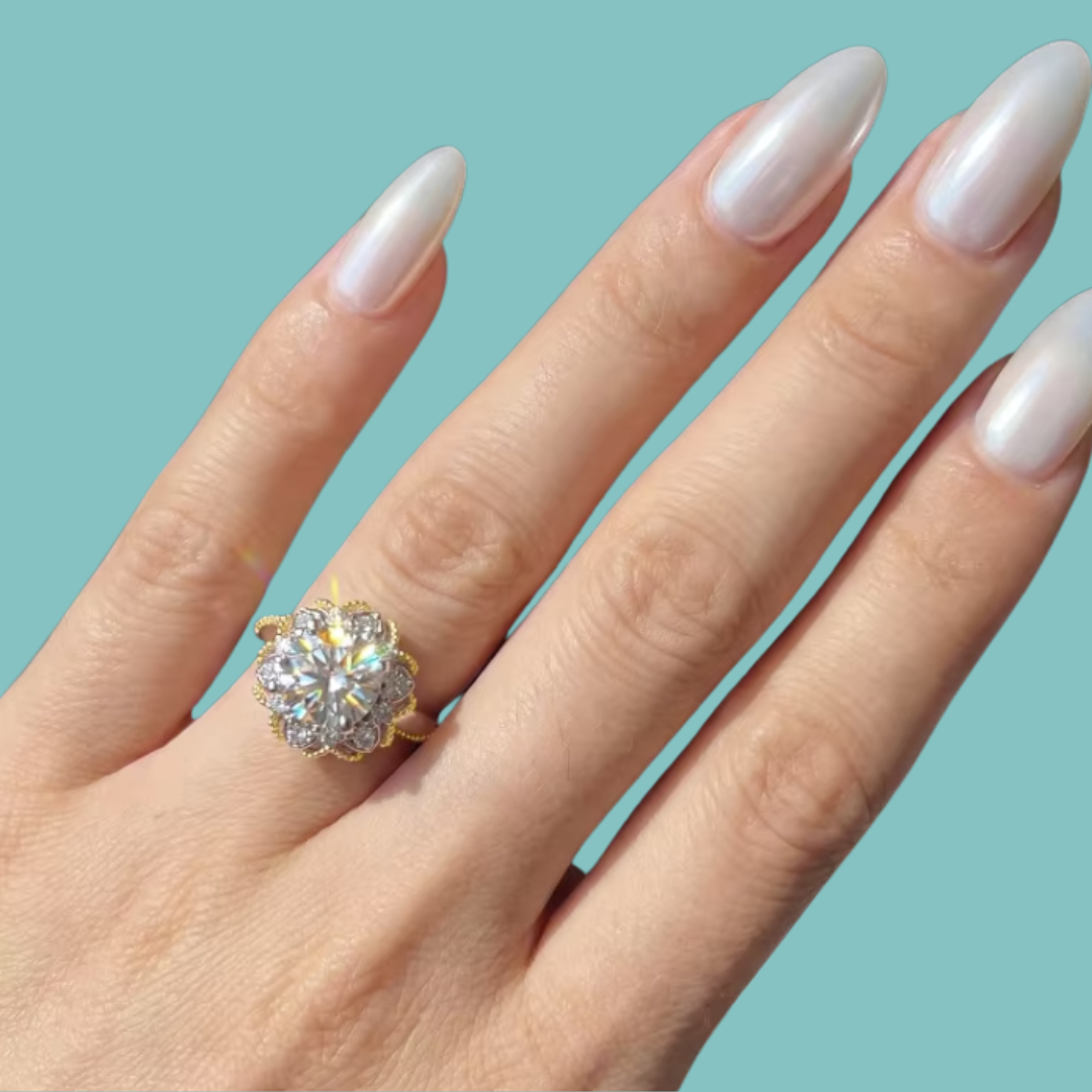Two-tone moissanite ring featuring a brilliant round centre stone and ornate decorative halo