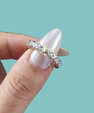 Delicate moissanite stacking band with sparkling round stones and repeating X design