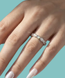 Silver moissanite eternity style ring with alternating round stones and kiss inspired X accents