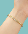 Close-up of a sparkling bezel moissanite bracelet held between fingers