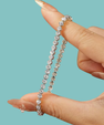 Close-up of a sparkling bezel moissanite bracelet held between fingers