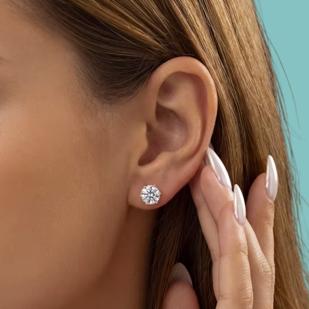 Round moissanite stud earrings in a warm gold-coloured setting, perfect for everyday sparkle.