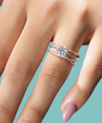 Sterling silver split band ring with round moissanite centre stone and pavé side detailing.