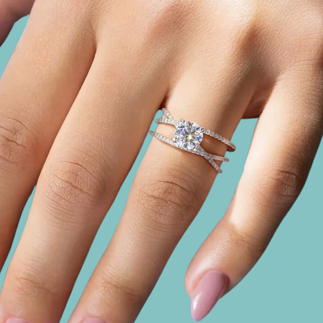 Sterling silver split band ring with round moissanite centre stone and pavé side detailing.
