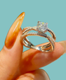 Round-cut moissanite ring featuring a split pavé band and polished sterling silver setting.