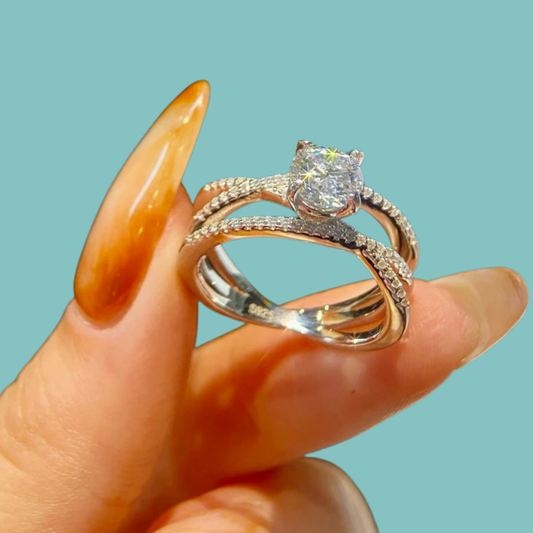 Round-cut moissanite ring featuring a split pavé band and polished sterling silver setting.
