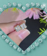 Close-up of sparkling four-petal moissanite flower stud earrings