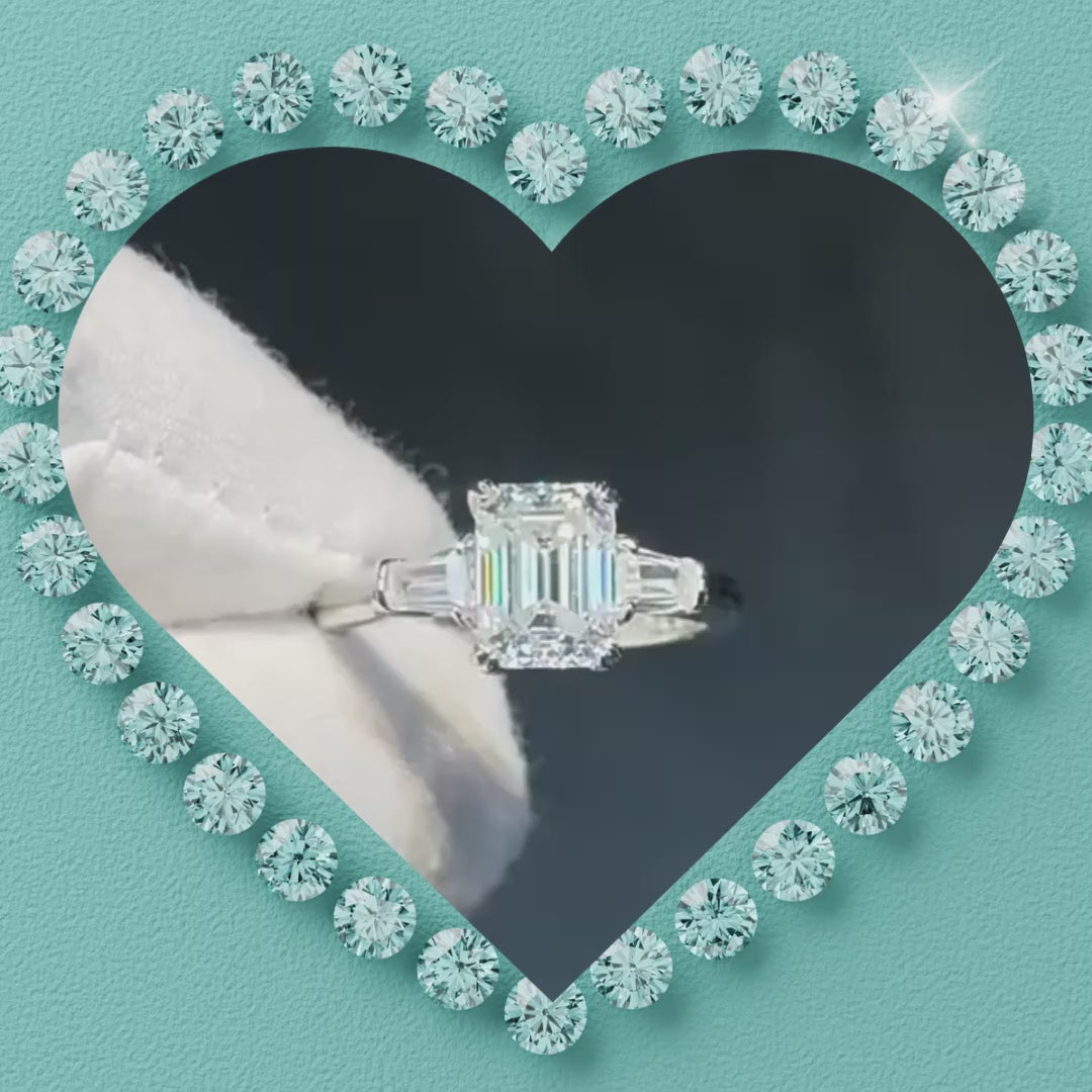 An emerald-cut diamond engagement ring with baguette side stones set in a silver-toned band